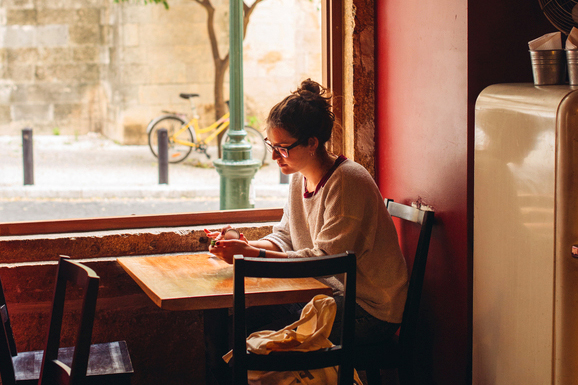 Girl sitting in a cafe trying to be productive